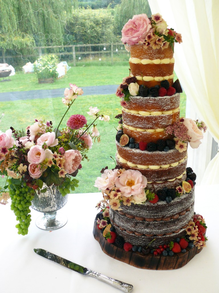 Semi-naked wedding cake with fresh flowers and love topper 